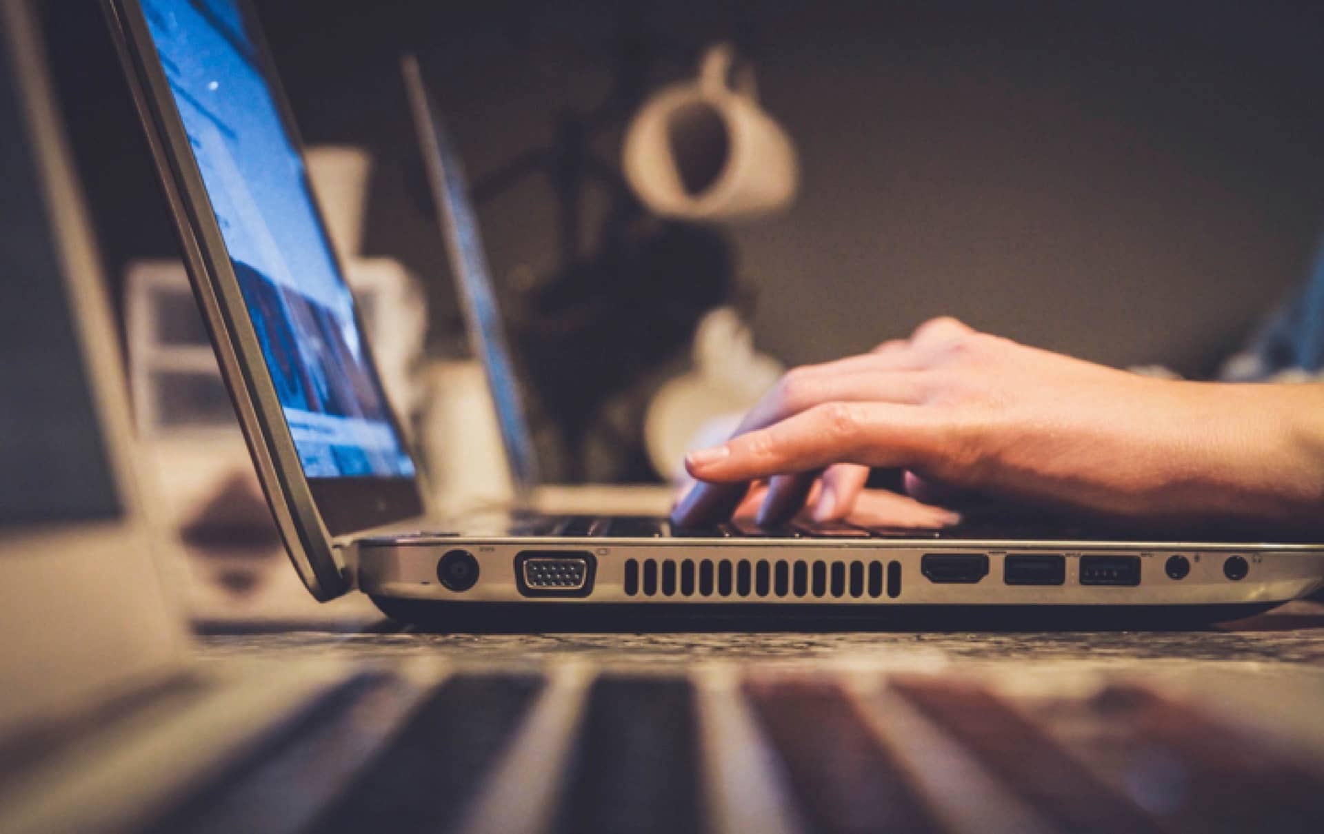 Someone unseen, typing on a laptop